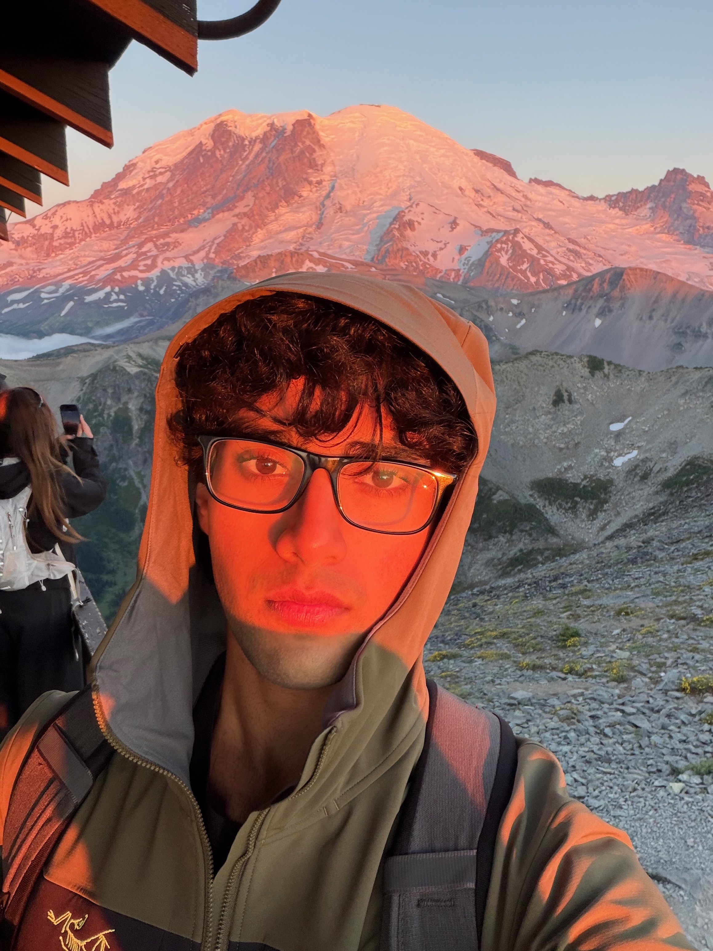 Yash on a sunrise hike with Mt. Rainier glowing pink in the background.